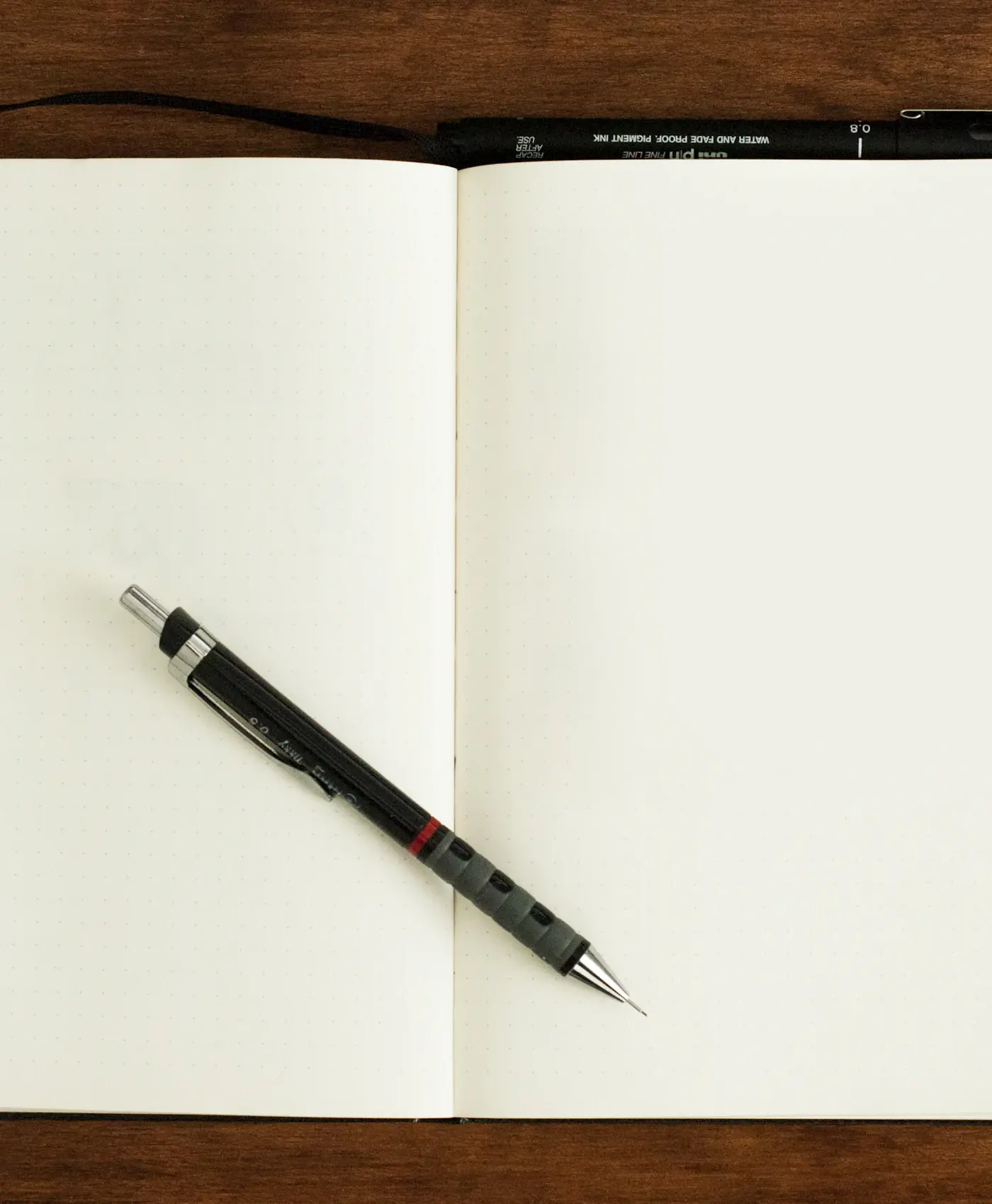 An open notebook with blank pages and a pen, ready for the first line