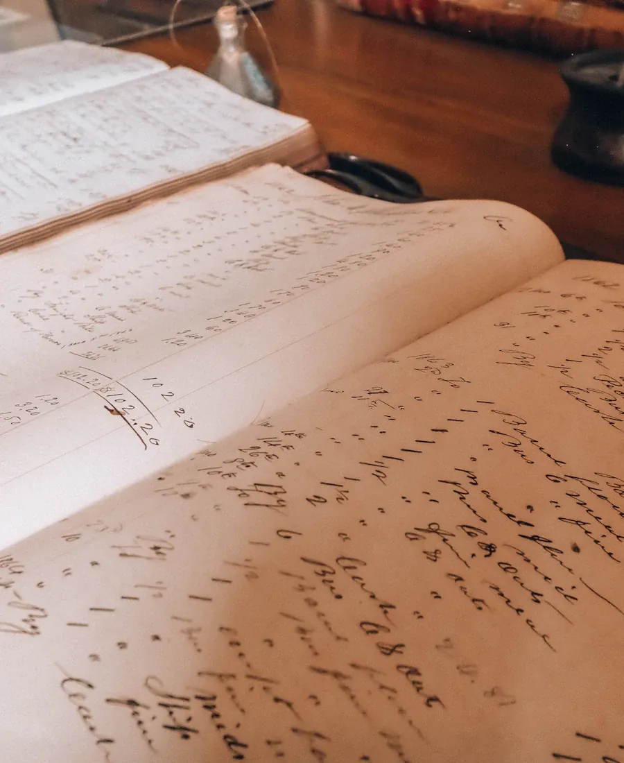 Open books of handwritten manuscript on a wooden table